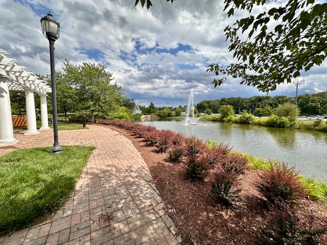 A walkway with a pond, where a fountain in center